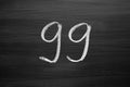 Number ninety nine enumeration written with a chalk on the blackboard