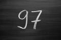 Number ninety seven enumeration written with a chalk on the blackboard