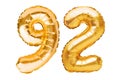Number 92 ninety two made of golden inflatable balloons isolated on white. Helium balloons, gold foil numbers. Party decoration, Royalty Free Stock Photo