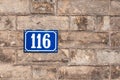 Number one hundred and sixteen painted on metal plate on brick w Royalty Free Stock Photo