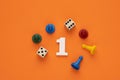 Number one in white with pieces and gambling dice - Orange eva rubber background Royalty Free Stock Photo