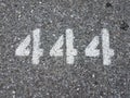 The number 444 painted on black asphalt Royalty Free Stock Photo
