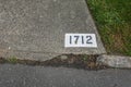The number 1712 painted on a concrete driveway with a white background