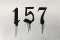 Number 157 painted in old letter with black paint at a wall Royalty Free Stock Photo