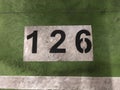 Number painted in white on a green background on the floor of a subway parking garage