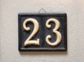 Number plate with numerals 23 hanging on wall