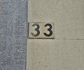 Number plate. Number thirty-three against wall background Royalty Free Stock Photo