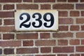 Number 239 on red brick wall, black numerals Royalty Free Stock Photo