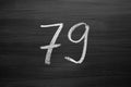 Number seventy nine enumeration written with a chalk on the blackboard