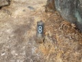 Number 8 on sign on ground with grasses Royalty Free Stock Photo