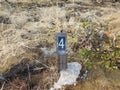 Number 4 on sign on ground with grasses Royalty Free Stock Photo