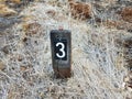 Number 3 on sign on ground with grasses Royalty Free Stock Photo