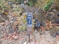 Number 7 on sign on ground with grasses and rocks Royalty Free Stock Photo