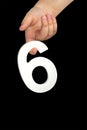 Number six in hand isolated on black background. Number six in a child's hand holding on a black background. To be Royalty Free Stock Photo