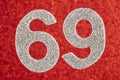 Number sixty-nine silver color over a red background. Anniversary. Royalty Free Stock Photo