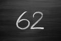 Number sixty two enumeration written with a chalk on the blackboard