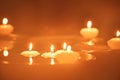 A number of small lighted candles floating in the water of a fountain