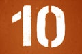 Number 10 in stencil on metal wall in orange tone