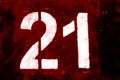 Number 21 in stencil on metal wall in red tone