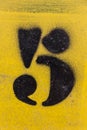 Number stencil painted on yellow background