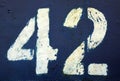 Number 42 in stencil on rusty blue metal wall