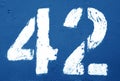 Number 42 in stencil on rusty metal wall in navy blue tone