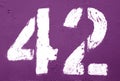 Number 42 in stencil on rusty metal wall in purple tone