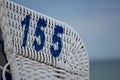 Number 155 stencilled in blue on a beach chair