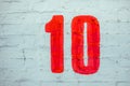 Number Ten Drawn By Red paint On Whitewashed Brick Wall. Shabby Building Facade With Damaged ÃÂ¡rack Plaster Royalty Free Stock Photo