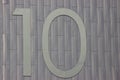 Number ten on a gray metal background. Different materials together. numeration