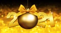 2021 number text with goden christmas ball and ribbon bow isolated on blurred lights background for happy new year greeting gift