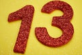 Number thirteen red color over a yellow background. Anniversary