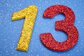 Number thirteen yellow red color over blue background. Anniversary