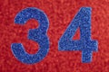 Number thirty-four blue color over a red background. Anniversary Royalty Free Stock Photo