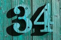 number thirty four turquoise wooden 34 sign on a wood wall with green-blue wood Royalty Free Stock Photo