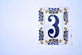 Number 3, three, decorative Spanish tiles on a white wall.