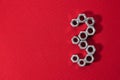 number three, made with steel nuts on red fabric background Royalty Free Stock Photo