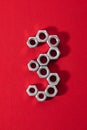 number three, made with steel nuts on red fabric background Royalty Free Stock Photo