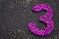 Number three purple color over a black background. Anniversary