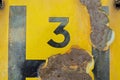 Number three on a rusty fire hydrant sign