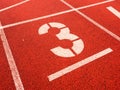 Number three. White track number on red rubber racetrack, Royalty Free Stock Photo