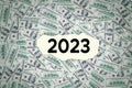 2023 number on torn paper with money background