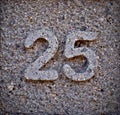 Number 25, twenty-five, on stone.