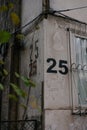 The number twenty five is painted using a stencil three time on a gray wall on the corner of the house, near window with Royalty Free Stock Photo