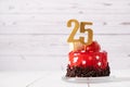 The number Twenty five on a red birthday cake on a light background Royalty Free Stock Photo