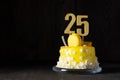 The number Twenty five on a yellow cake for an anniversary or birthday in a dark key Royalty Free Stock Photo