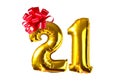 Number twenty one of golden helium balloons with red bow, on white background Royalty Free Stock Photo