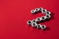 number two, made with steel nuts on red fabric background Royalty Free Stock Photo