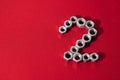 number two, made with steel nuts on red fabric background Royalty Free Stock Photo