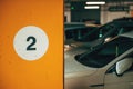 Number 2 on underground parking garage wall with cars in background Royalty Free Stock Photo